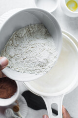 Pouring flour into a sieve, sifting flour for baking