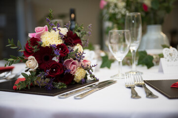 Wedding bouquet of flowers on reception table ready for evening meal and party