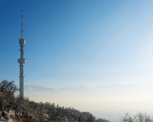 Almaty Television Tower and mountain view during winter smog.  Kazakhstan