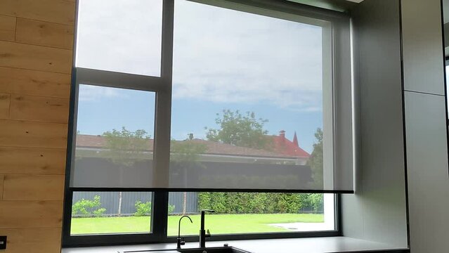Motorized roller blinds. Automatic solar shades on the window in the kitchen. Screen material for roller blinds.