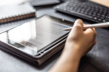 Woman working with digital tablet and pen, checking document, contract or agreement - Close up