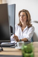 An accountant or businesswoman works in her office at a computer