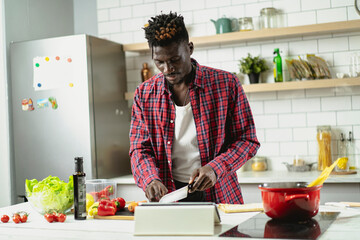 African man cooking in modern kitchen. Handsome chef preparing food