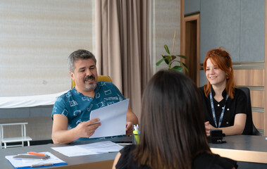 patient and doctor, Doctor examining patient's lab results. Doctor's assistant next to him treats the patient with a smiling face