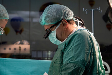 Open heart surgery, doctors and cardiologists perform open heart surgery. Doctors in green uniforms in the operating room.