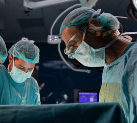 Open heart surgery, doctors and cardiologists perform open heart surgery. Doctors in green uniforms in the operating room.