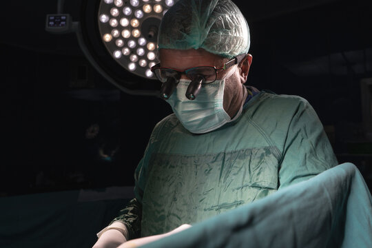 Open heart surgery, doctors and cardiologists perform open heart surgery. Doctors in green uniforms in the operating room.
