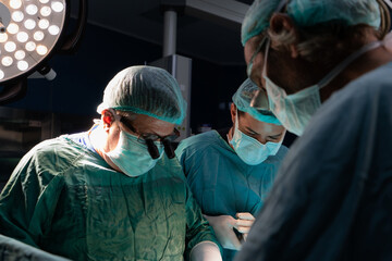 Open heart surgery, doctors and cardiologists perform open heart surgery. Doctors in green uniforms in the operating room.