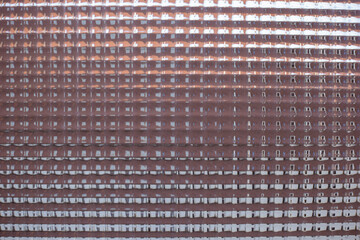 Embossed texture of pink glass, uneven background of the glass surface. Window pattern