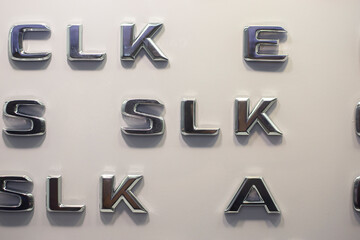Letters of the English alphabet in silver color on a light wall