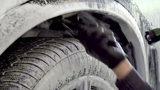Close Up Of Hand Of Worker Man Washes And Scrubs Car Wheels With Special Brush