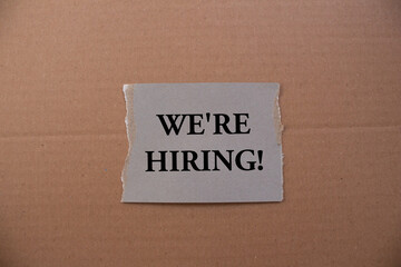 we're hiring! written on teared paper. Business concept photo.