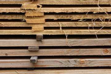 A close-up of a pile of planks at a sawmill. The distance between the planks allows them to dry properly.