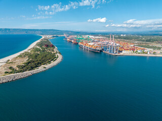 Naklejka na ściany i meble Aerial view of the port of Gioia Tauro, Calabria Italy. Goods loading and unloading operations. Container. Import and export. Global trade. Movement of goods by ship. Transportation. 31-08-2022