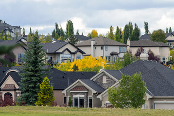 Calgary NW neighborhood of Valley Ridge, close up of suburban homes on a hill, fall foliage