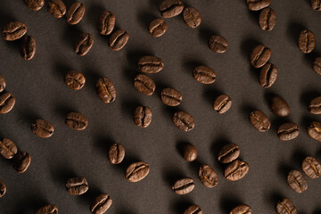 Roasted coffee beans and ground coffee background. Many aromatic coffee beans on a dark background. View from above. The concept of an advertising banner for a coffee shop or commodity production.