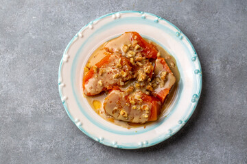 Pumpkin dessert with tahini and walnuts on a white porcelain plate
