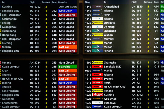 Changi Airport, Singapore - January 24, 2020: Real photo of flight departures board fragment in Singapore airport viewed from the main corridor