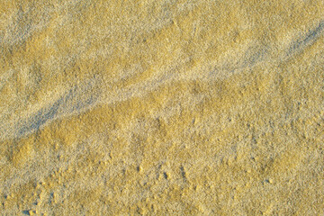 Natural background texture of frozen sand close-up.