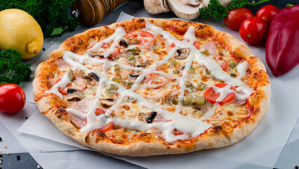 Italian pizza with mushrooms, tomatoes, ham, pickled cucumber, cheese and sauce.