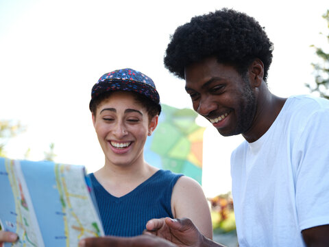 Smiling Woman And Man Reading A Map Outside