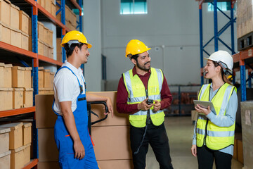 Asian employees work together to check goods in a large warehouse.