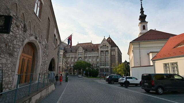 Budapest,Hungary,August 2022. POV footage walking along the streets of pest , on the city hill. The colorful facades of the houses line the street. In the background the National Archive of Hungary