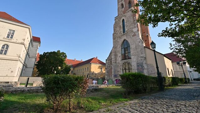 Budapest,Hungary,August 2022. On the city hill the Church of St. Mary Magdalene. A group of tourists stopped in front to observe her, tilt. Beautiful summer day.
