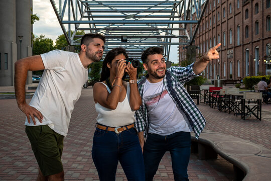 Grupo de amigos siendo turistas en la ciudad de Rosario. Uno de ellos se&ntilde;ala algo divertido