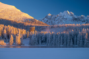 A winter's morning at Strbske Pleso, with the High Tatras standing tall and the lake reflecting the sun's first rays.