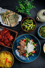 Asian banquet duck fillet salad, beans, sweet and sour chicken, rice noodles with vegetables, homemade cheese with spinach and spices, Indian cheese and spinach tortillas.