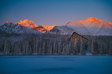 The breathtaking beauty of a winter sunrise in the High Tatras, seen from the frozen surface of Strbske pleso lake.