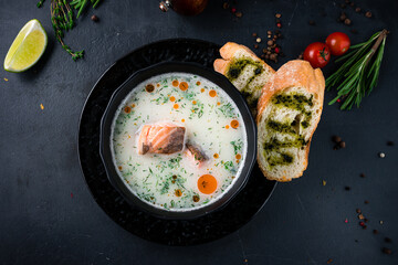 Finnish lunch fish soup with salmon, cream, potatoes, dill and bread with sauce and spices.