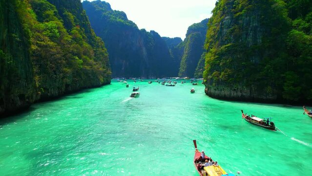 Drone flying over the clear blue waters and limestone hills in tropical sea. One of the most beautiful wonders in the world. Phi Phi Island, Thailand. Paradise ocean video. Travel and holiday concept
