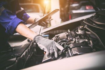 Car care maintenance and servicing, Hand technician auto mechanic checking inspection list after...