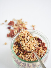 Metal spoon in glass jar with granola