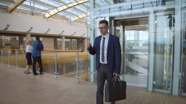 Tired stressed businessman walk out of elevator going to work in morning