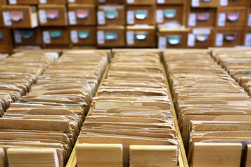 Library catalogue cards in old wooden box. File archive, opened drawers with paper documents,...