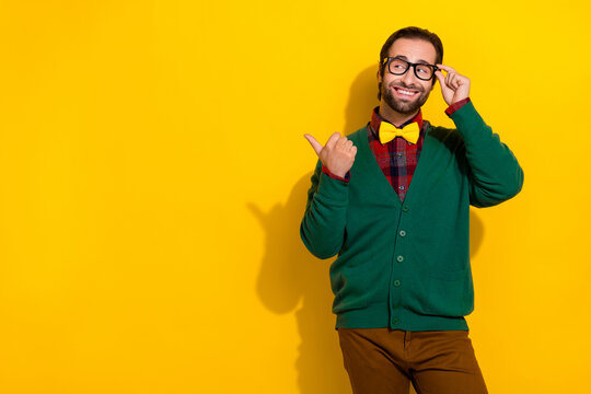 Photo portrait of attractive male touch specs point empty space toothy smile dressed stylish green look isolated on yellow color background