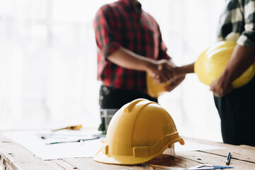 Close up handshake of two engineers. Group of industries workers meet on manufacture site shake hands.