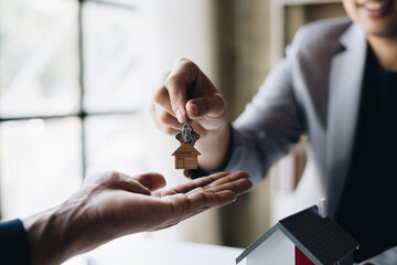 real estate agent giving key from house to costumer.