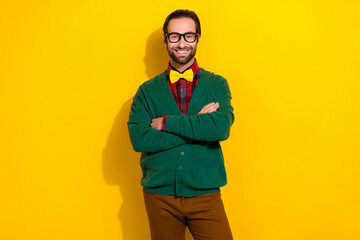 Photo portrait of young nice guy spectacles crossed arms beaming smile dressed stylish green clothes isolated on yellow color background