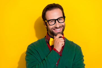 Photo portrait of young attractive male specs touch chin toothy smile dressed stylish green look isolated on yellow color background