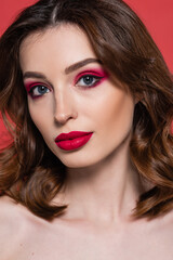 Fototapeta na wymiar portrait of young woman with magenta color makeup and bright lipstick looking at camera isolated on pink.