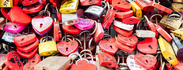Verona, Italy - June 2022: background of heart-shaped locks on a wall, symbol of love forever.
