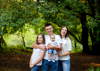 happy family walking together in the park. friendly family kid dream concept. lifestyle family walking in the park on the grass at sunset.