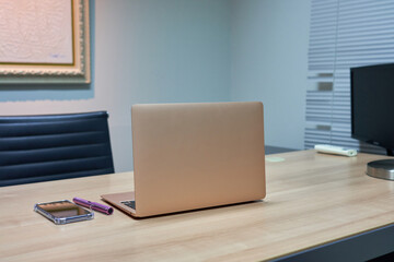 Computer notebook with phone pen on wood working table.