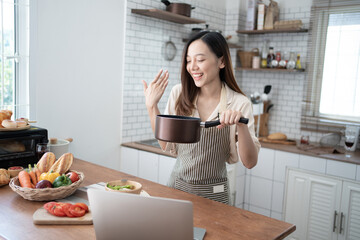 Lovely Asian woman enjoy her time in the kitchen, happy domestic lifestyle.