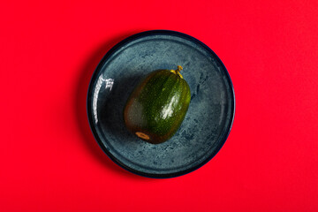 Vegetable marrow on the red backdrop.