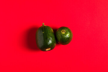 Vegetable marrow on the red backdrop.